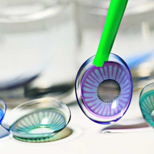 Contact lens being held by tweezers
